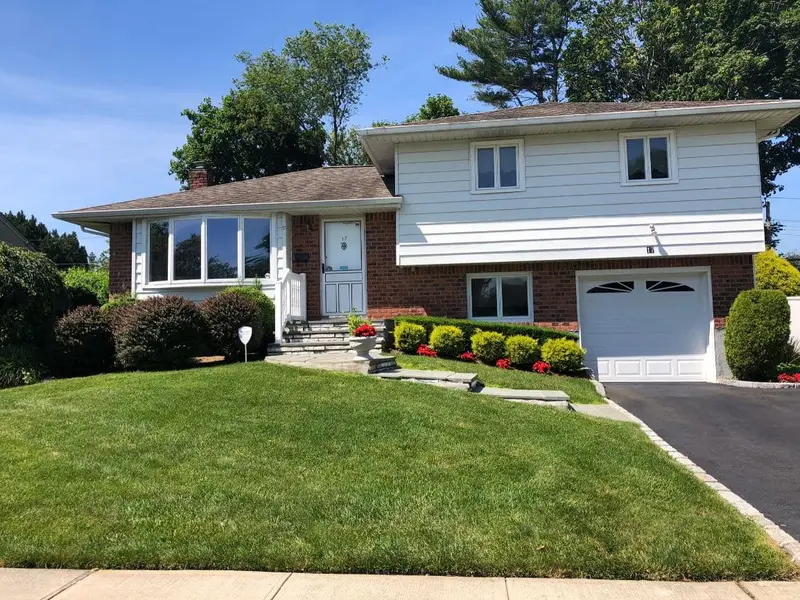 Split-level with a brick lower story and an attached garage, Plainview, NY